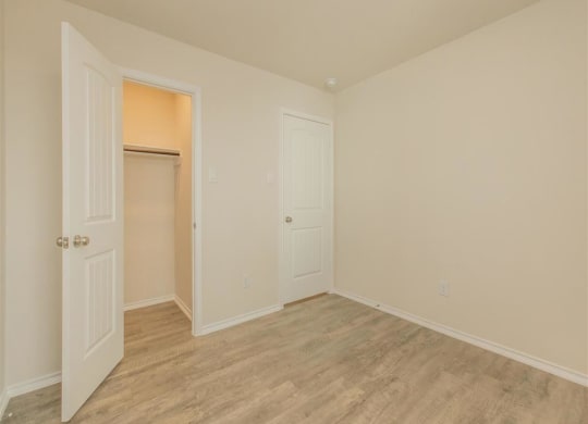 a bedroom with a closet and a door open at The Village at Granger Pines, Conroe, TX 77302