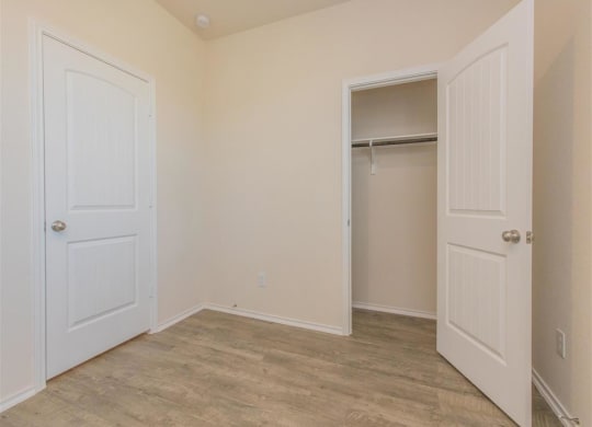 a bedroom with two doors and a closet at The Village at Granger Pines, Texas, 77302