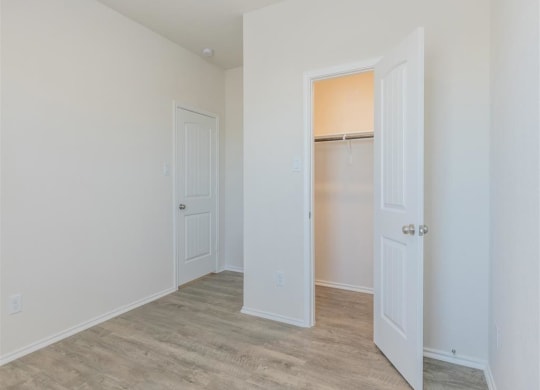 a bedroom with two doors and a closet at The Village at Granger Pines, Texas