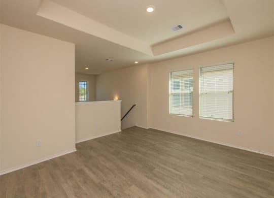 an empty room with a counter and three windows at The Village at Granger Pines, Conroe