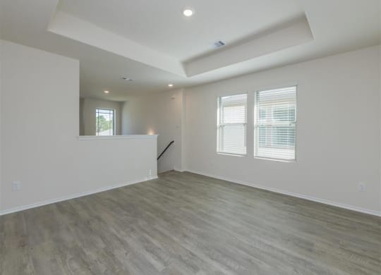 an empty room with a counter and three windows at The Village at Granger Pines, Conroe, TX