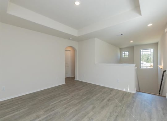 a large room with white walls and a wooden floor at The Village at Granger Pines, Conroe, TX 77302
