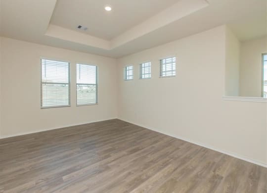 an empty room with white walls and a wooden floor at The Village at Granger Pines, Texas, 77302