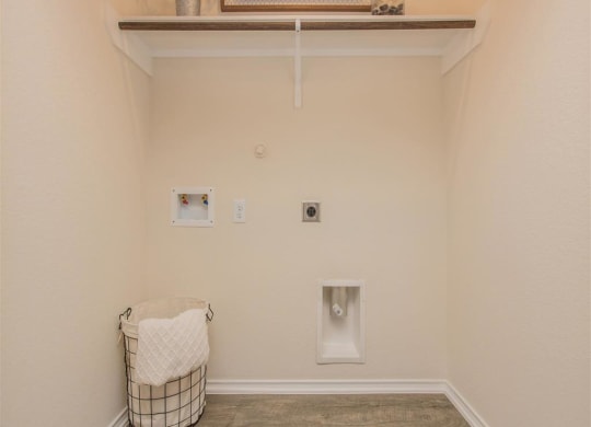 a laundry room with a basket and a picture on the wall at The Village at Granger Pines, Texas, 77302