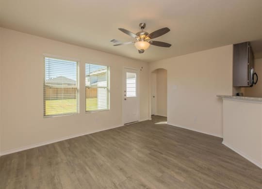 an empty living room with a ceiling fan at The Village at Granger Pines, Conroe, TX