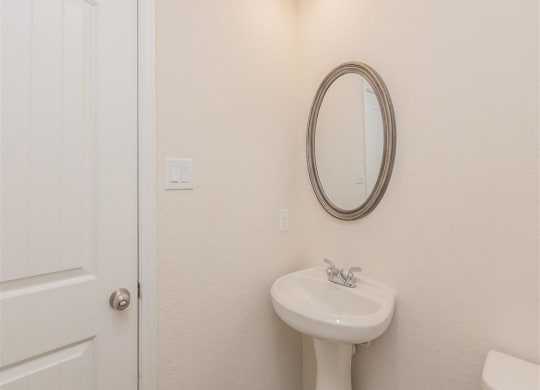 a bathroom with a sink and a mirror at The Village at Granger Pines, Conroe, TX
