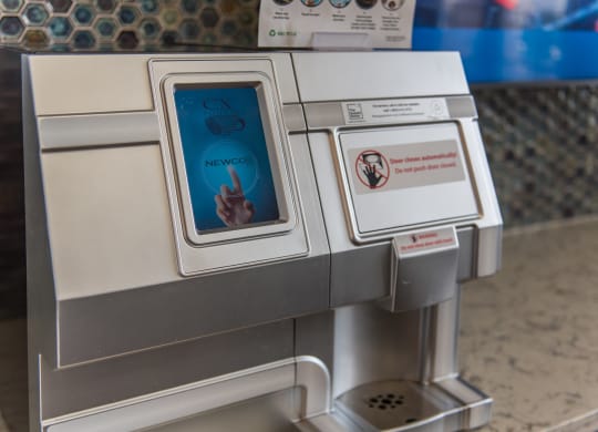 an atm machine with a screen showing a hand pressing a button at The Whitworth, Williamsburg, 23185