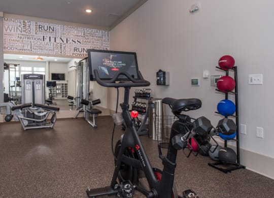 a spacious exercise room with cardio equipment and a treadmill at The Whitworth, Virginia, 23185
