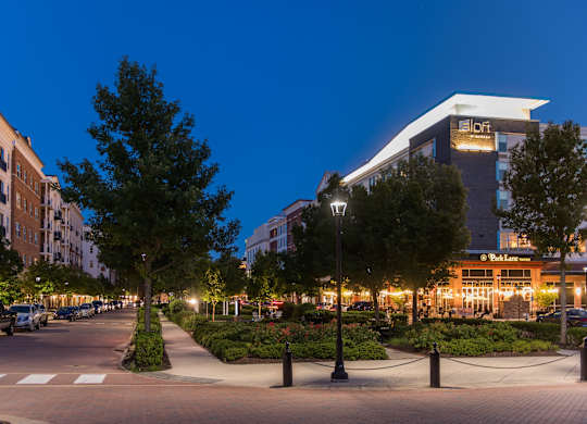 a city street at night with buildings and trees