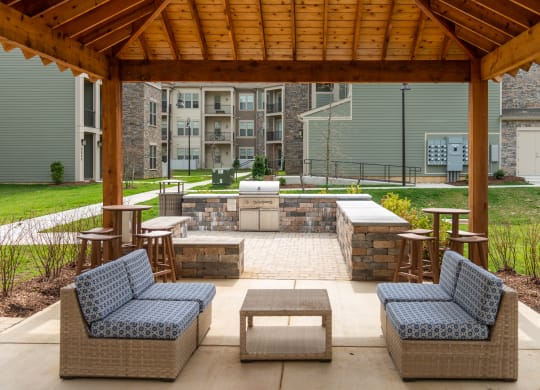 a covered patio with wicker furniture and a fire pit at The Whitworth, Williamsburg, Virginia