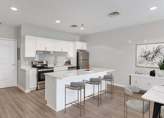 an open kitchen and dining area with a white island and stools