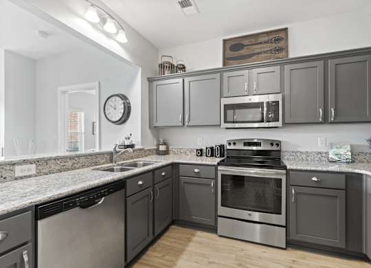 A kitchen with dark cabinets and stainless steel appliances.