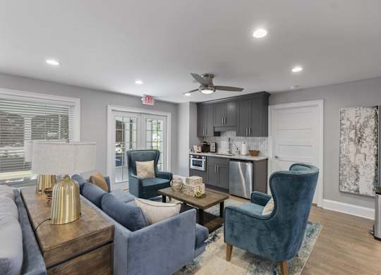 A living room with a blue chair and a grey couch.