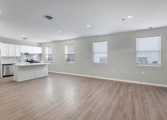 A spacious kitchen with a white island and wooden flooring.