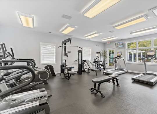 a gym with treadmills and other exercise equipment and windows