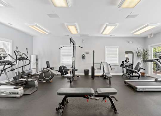 a gym with treadmills and other exercise equipment and windows