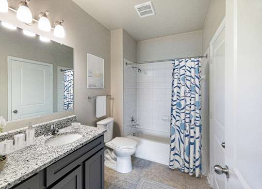 A bathroom with a white toilet, sink, and shower.