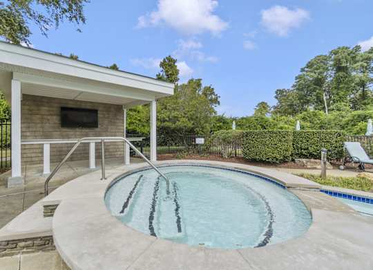 a hot tub and pool in a backyard with a pool house