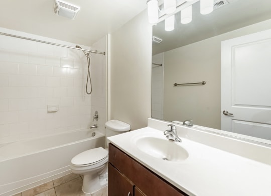a bathroom with a sink toilet and shower and a mirror at Mayton Transfer Lofts in VA 23803