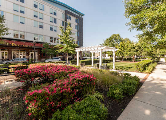 a sidewalk in front of a building with a white gazebo