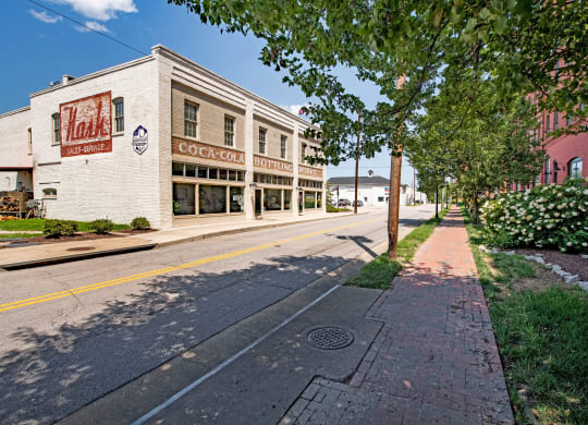 a city street with a building and trees on the side of it at Mayton Transfer Lofts in Petersburg, 23803