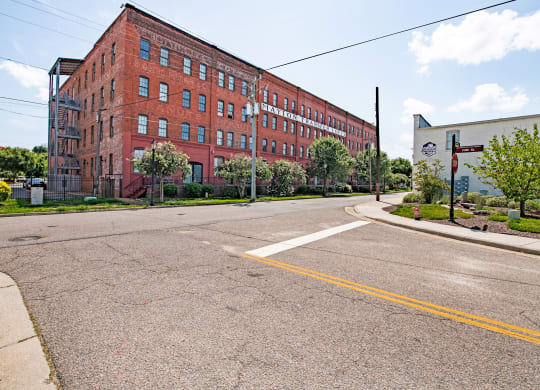 an empty street in front of a red brick building at Mayton Transfer Lofts in Petersburg, VA 
