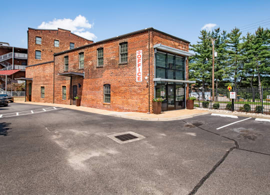 a red brick building with a sign on the side of a street at Mayton Transfer Lofts in Petersburg, Virginia 23803