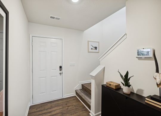 an entryway with stairs and a white door and a stairwell with a plant at Summit Place Apartments, Oak Ridge