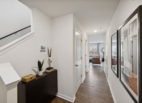 a hallway with white walls and a wooden floor with a staircase and a glass door at Summit Place Apartments, Oak Ridge