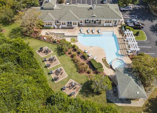 an aerial view of a swimming pool and a house with a yard and a lawn