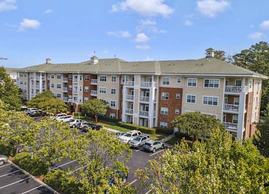 an aerial view of an apartment building with a parking lot