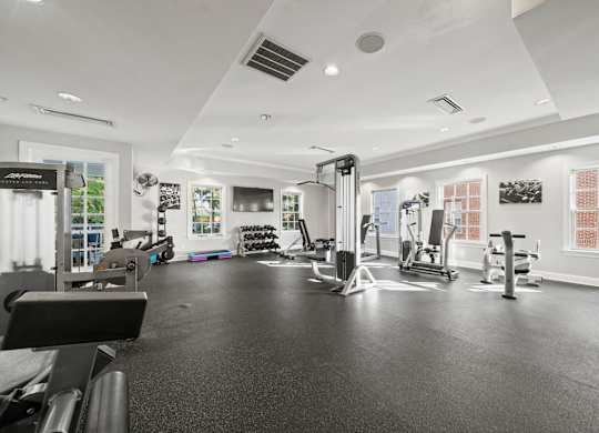 A black and white photo of a gym with various exercise equipment.