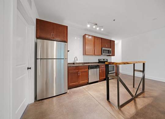 A kitchen with a wooden table and stainless steel appliances at Skyloft in Asheville, 28803