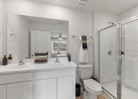 a white bathroom with a shower and a sink and a toilet at Summit Place Apartments, Oak Ridge, Tennessee