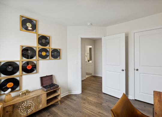 a living room with a gallery of records on the wall at Summit Place Apartments, Oak Ridge, Tennessee