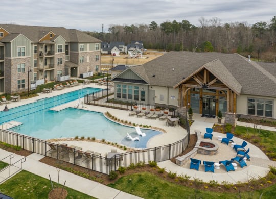 an aerial view of a resort style pool with lounge chairs and a clubhouse in the background at The Whitworth, Williamsburg, VA