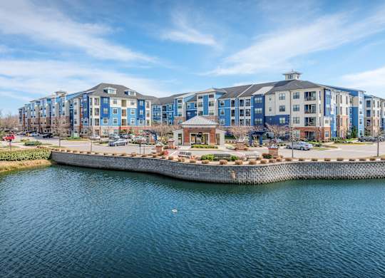A large building complex sits on the edge of a body of water.