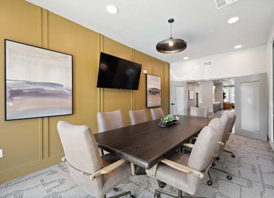 A conference room with a long table and chairs.