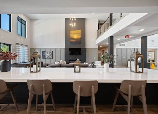 A modern kitchen with a long island and chairs.