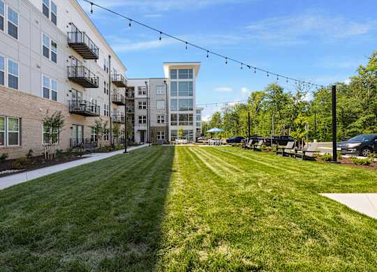 A long grassy area with apartment buildings on either side.