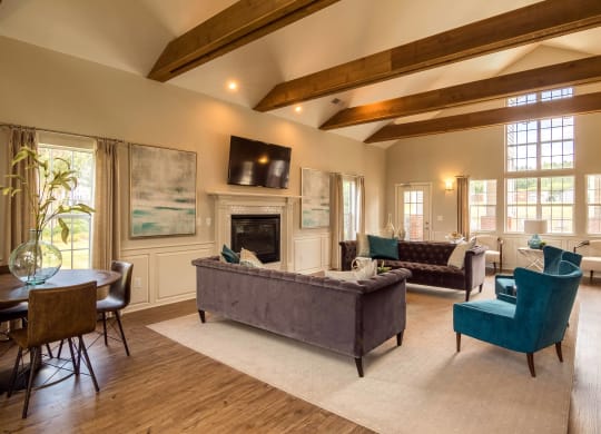 a living room with couches and chairs and a fireplace at Abbington Place Apartments, Greensboro
