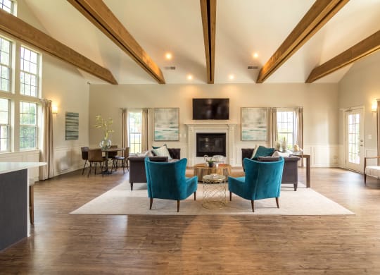 a living room with blue chairs and a fireplace at Abbington Place Apartments, Greensboro , NC 27407