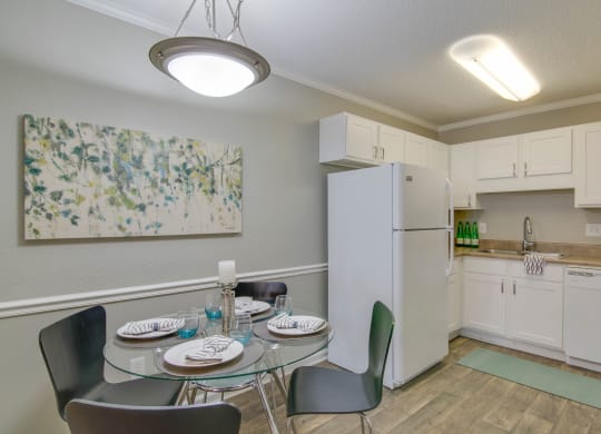 a kitchen and dining room with a table and chairs and a refrigerator at Abbington Place Apartments, North Carolina
