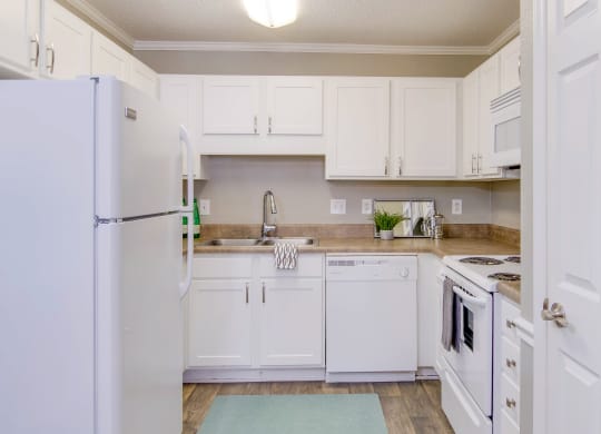 a kitchen with white cabinets and appliances and a refrigerator at Abbington Place Apartments, North Carolina