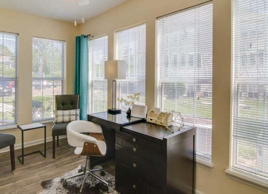 a home office with a desk and chairs and large windows at Abbington Place Apartments, Greensboro , NC 27407