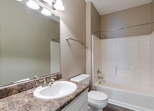A bathroom with a sink, toilet, and bathtub.