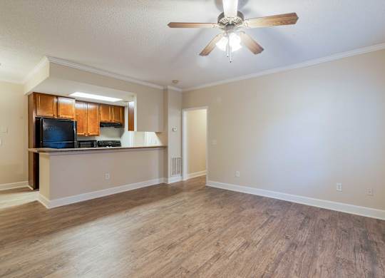 A room with a ceiling fan and wooden flooring.