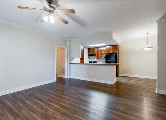 A room with a ceiling fan and wooden flooring.