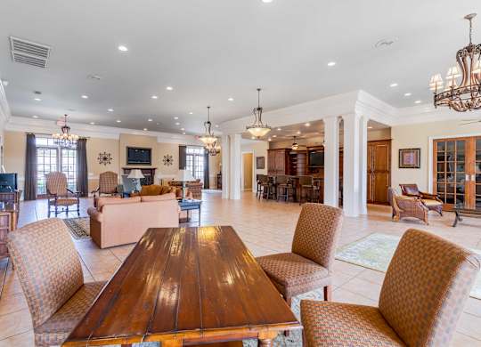 A large, well-lit dining room with a wooden table and chairs.