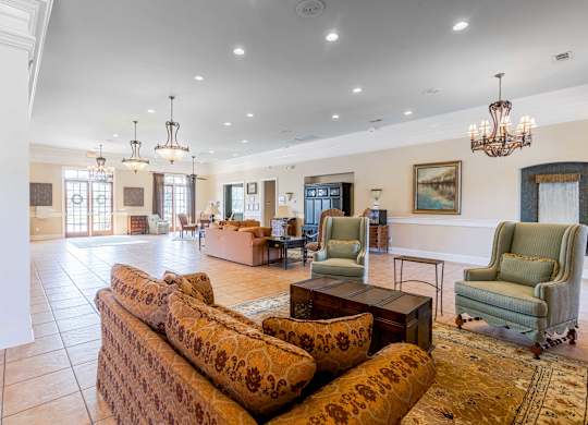 A large, well-lit living room with a sofa set and chairs.